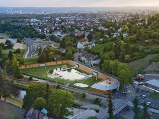 Zur Strasse hin wird das Bad von einer hölzernen Umfassungswand abgeschirmt. Der Blick in die Auenlandschaft ist frei.
