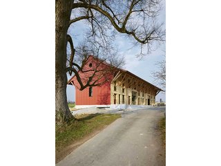 An der Westfassade schützen rote Wellplatten aus Faserzement vor der Witterung. Links im Bild die alte Linde, die einst dem Hof seinen Namen gab. Beim Bau der Wohnscheune wurde penibel darauf geachtet, dass sie keinen Schaden nimmt.
