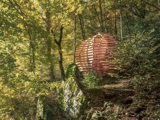 Versteckt im Wald, abseits des Wanderwegs: «Sphere» bietet spannende Ein- und Ausblicke auf Rossa und die Landschaft. Der Pavillon aus lokalem Lärchenholz ist 4,5 Meter hoch und hat einen Durchmesser von 6,4 Meter. 
