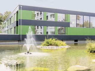 Unruhe und Weglauftendenz sind für die Demenzkrankheit typisch. Der Teich auf der einen, Garten, Kleintiergehege und ein anliegender Spielplatz auf der anderen Seite begrenzen das Areal. In der Mitte liegt der 2019 eröffnete Neubau.

