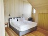 Der Blick in eines der Gästezimmer offenbart auch viel Holz im Innenausbau. Die Böden bestehen aus heimischer Douglasie, die Wände aus Weisstanne.