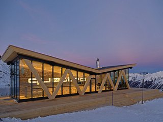 Der Kontrast zwischen unbehandeltem Holz und den grossen Glasfronten verleiht dem Gebäude gleichzeitig Naturverbundenheit und Eleganz
