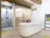 Im Untergeschoss ist das Badezimmer mit Dusche, freistehender Badewanne und Sauna untergebracht.
