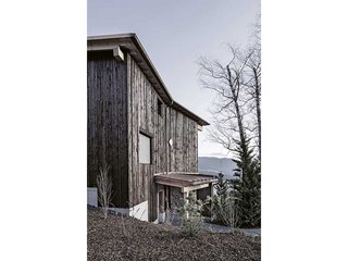 Vertikale Bretter aus druckimprägniertem Schwartenholz, zwischen 40 und 70 Millimetern breit, zieren die Fassade.
